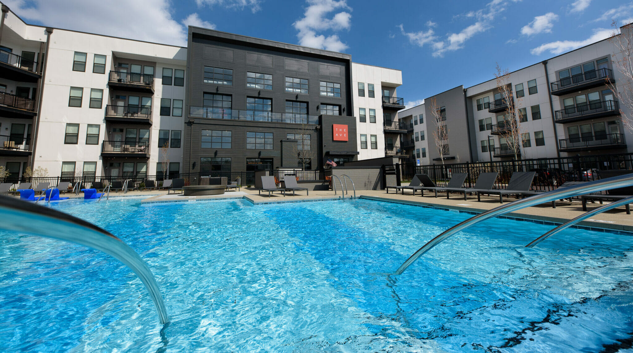 Outdoor swimming pool and exterior buildings at The AVE community.
