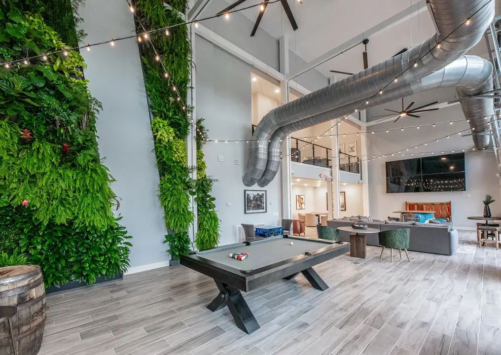 Indoor party area with large TV, pool table and modern furniture.